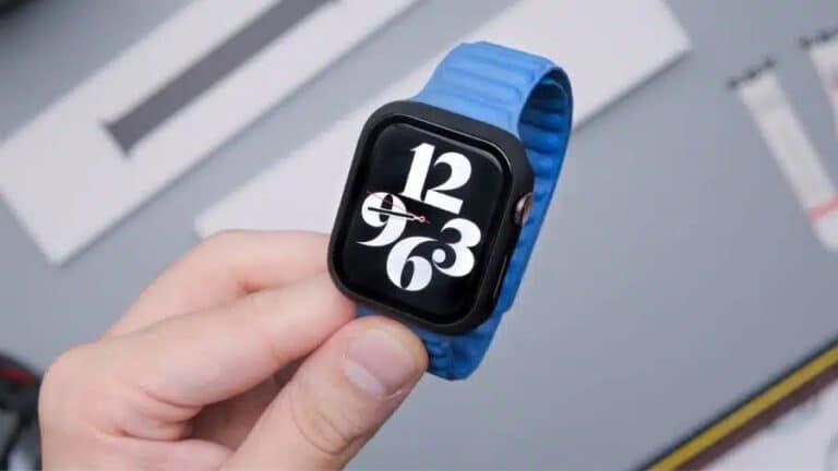 Pessoa segurando um smartwatch com pulseira azul e mostrador digital exibindo números grandes em tela