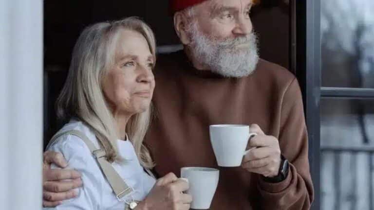 casal de idosos usando smartwatch e tomando cafe numa manhã