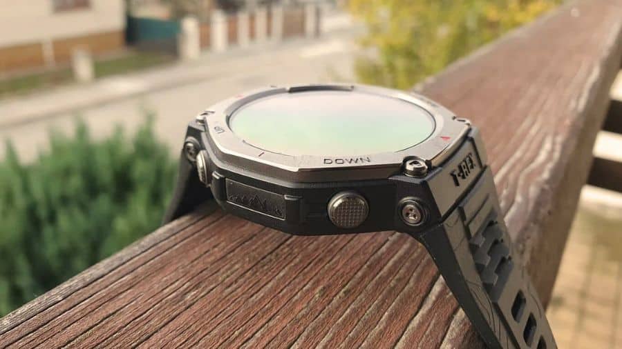 Vista lateral do smartwatch Amazfit T-Rex 3 com detalhes da caixa e botões, posicionado sobre superfície externa